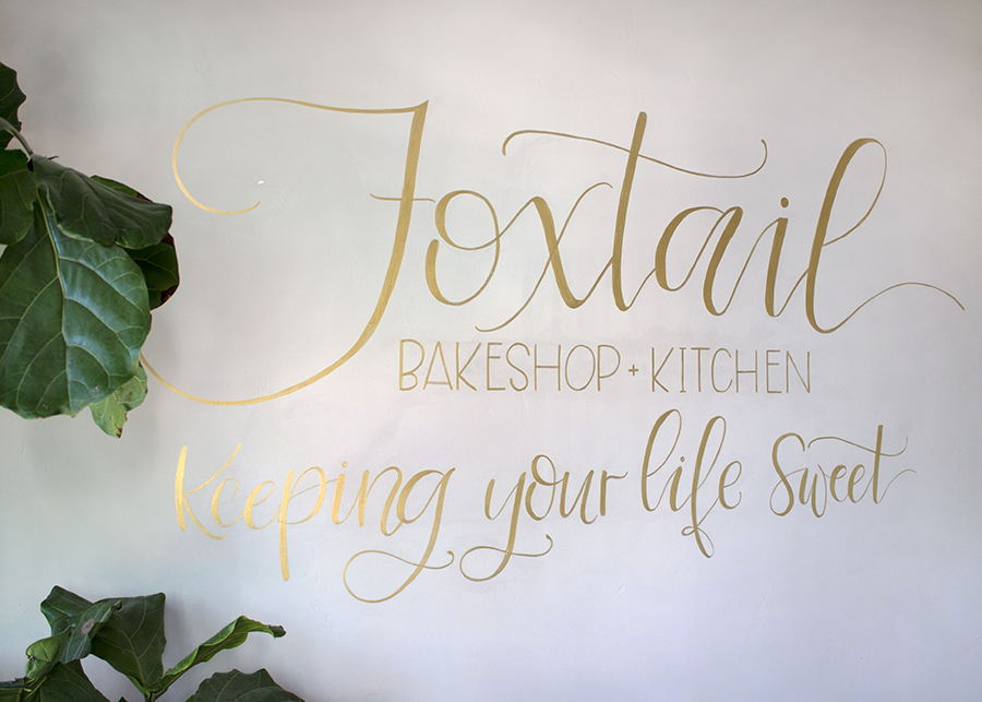 The Foxtail Bakeshop painted in gold, scrolled text “Keeping your life sweet”
